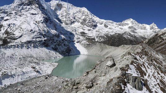 Gletschersee unterhalb eines schneebedeckten Berggipfels