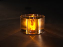 Gelb leuchtender Kristall in einem runden, durchsichtigen Gehäuse.