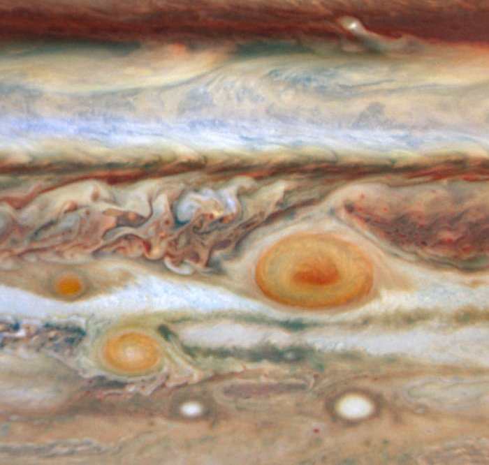 Drei rote Flecken auf Jupiter Drei unterschiedlich große rote Flecken innerhalb verwirbelter Wolkenband-Strukturen.