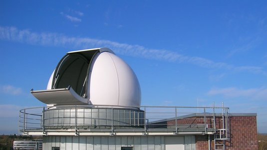 Ein freistehendes Gebäude mit geöffnetem Kuppeldach