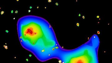 Falschfarbenaufnahme: Diffuse Wolke; innen weiß, nach außen schalenartig erst Rot, dann Gelb, Grün und Hellblau; schließlich ins Blau des übrigen Bildes übergehend.