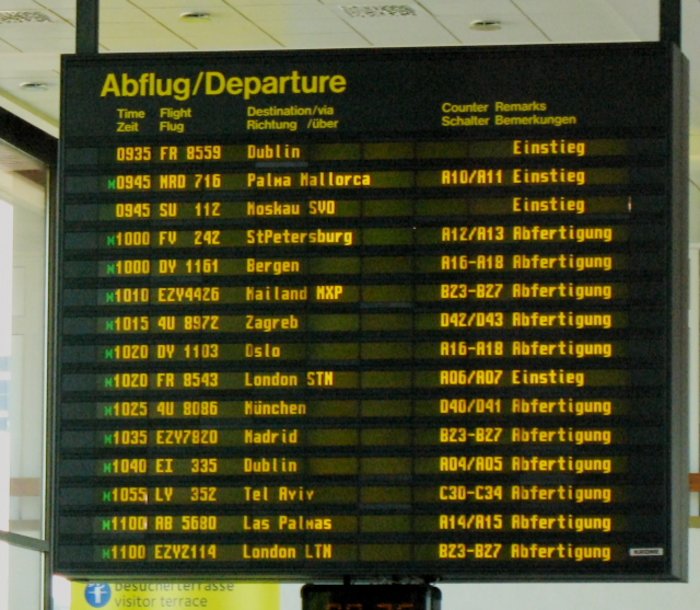 Durch ALD erzeugtes Display Große elektronische Tafel am Flughafen mit Infromatonen zu den Flügen, gelb leuchtende Buchstaben auf schwarzem Display