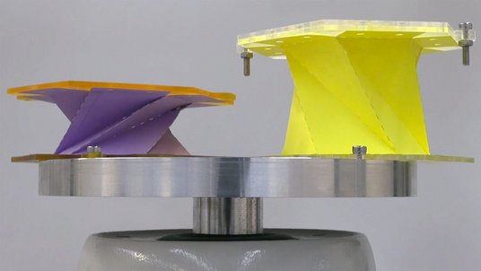 Zwei Papierbälge mit unterschiedlicher Höhe stehen auf einem metallisch glänzenden Teller.