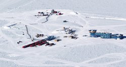 Luftbild einer schneebedeckten Ebene mit einigen Gebäuden.