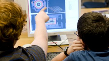 zwei Jungen untersuchen Teilchenspuren am Computer