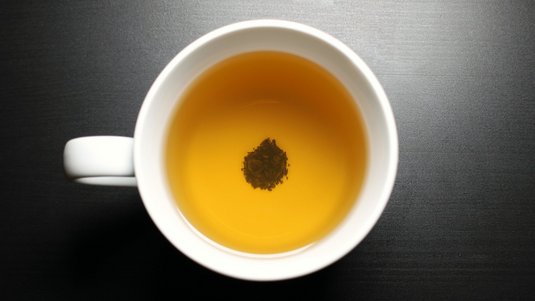 Blick in eine Teetasse – am Boden ein Häufchen aus Teeblättern