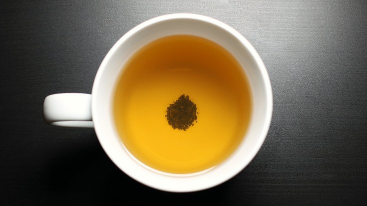 Blick in eine Teetasse – am Boden ein Häufchen aus Teeblättern