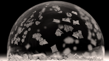 Kristalle auf einer Seifenblase in Nahaufnahme vor schwarzem Hintergrund