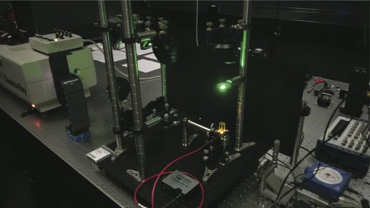 Technischer Aufbau, der grünes Licht abstrahlt.