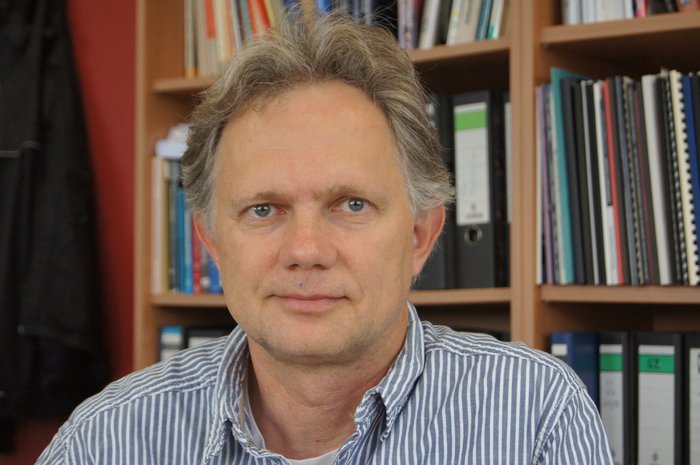 Frank Bertoldi vom Argelander-Institut für Astronomie an der Universität Bonn vor einer Bücherwand.