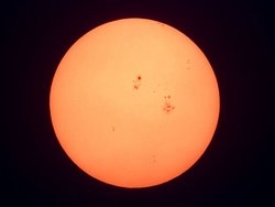 Das Bild zeigt die Scheibe der Sonne, auf der mehrere Gruppen dunkler Flecke zu erkennen sind.