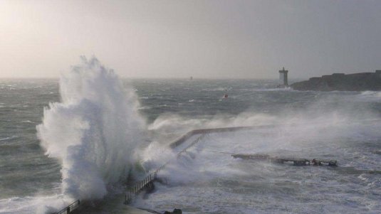 Das Meer ist unruhig und Wasser spritzt an einer Brücke hoch