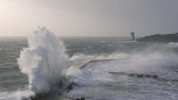 Das Meer ist unruhig und Wasser spritzt an einer Brücke hoch