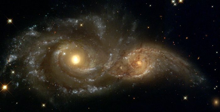 Zwei große Spiralgalaxien ganz dicht nebeneinander; die linke ist etwas größer als die rechte; die Spiralarme scheinen sich zu berühren.