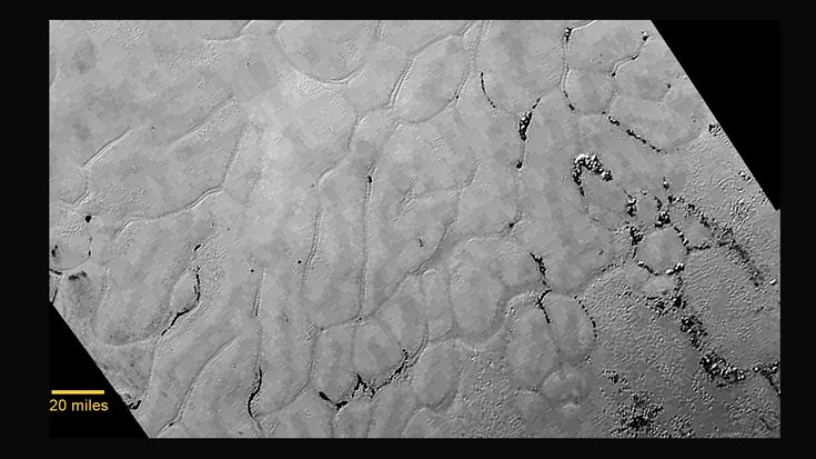 Eisoberfläche auf Pluto, Bildquelle: NASA; Lizenz: gemeinfrei Planetenoberfläche mit geschwungenen Adern und vertreuten Eisbrocken.