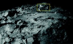 Ausschnitt der Oberfläche des Kometen Tschurjumow-Gerassimenko. Oberhalb einer flachen Ebene sind helle Flecken zu erkennen.