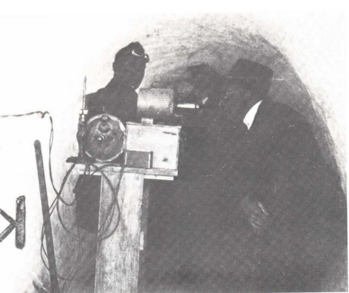 Strahlungsmessung in einem Stollen Schwarzweiss-Foto: zwei Männer vor einer technischen Messaparatur in einem Tunnel.