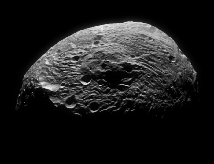 Der Asteroid Vesta Foto. Felsiger Himmelskörper, der mit Kratern und Narben übersät ist.