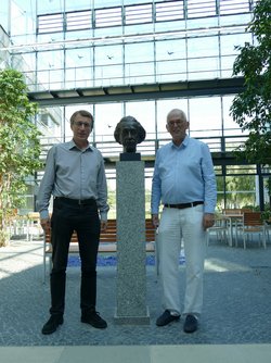 Das Bild zeigt die beiden Forscher Krzysztof Meissner und Hermann Nicolai. Zwischen ihnen steht eine Skulptur von Albert Einstein.