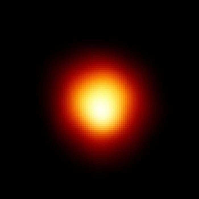 Hubble-Aufnahme des Riesensterns Beteigeuze Auf schwarzem Untergrund ist eine Scheibe zu sehen, die am Rand rot, zur Mitte hin gelb und schließlich weiß ist. Das Helligkeitsmaximum befindet sich etwas unterhalb der Scheibenmitte.