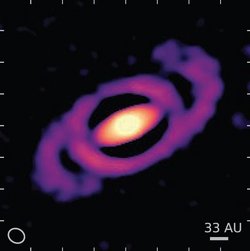 Helles Objekt, umgeben von einer Ellipse, von der symmetrisch zwei Spiralarme ausgehen.