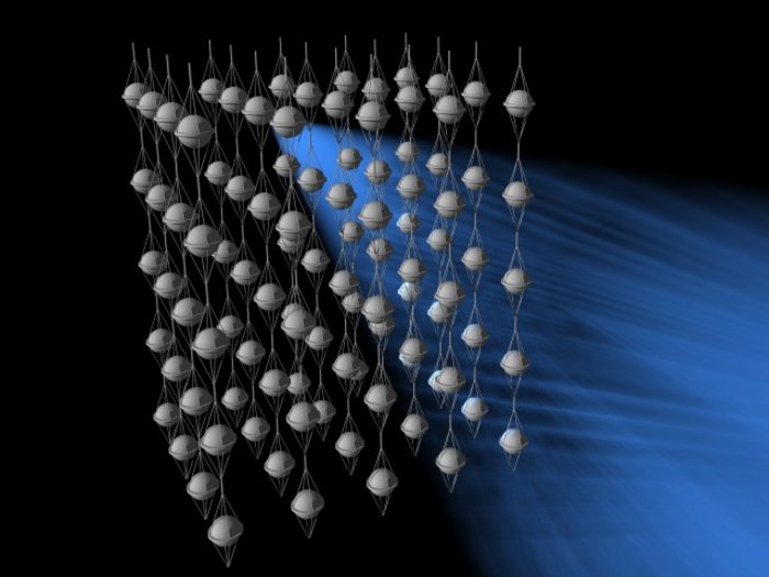 Lichtsensoren eines Neutrinoteleskops Schematische Darstellung von zahlreichen kugelförmigen Lichtsensoren, die an langen Trossen aufgehängt sind und insgesamt einen großen Würfel bilden. Eingezeichnet ist außerdem ein blauer Lichtblitz.