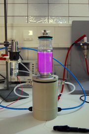 In einer Plasmakammer wird Stickstoffgas ionisiert und leuchtet dadurch rosa