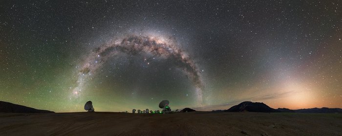 Vor einem Sternenhimmel und einer hügeligen Landschaft sind einige Radioantennen zu erkennen.