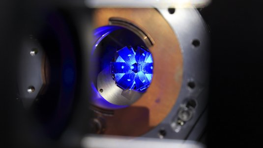 Runde Öffnung von Metallteilen mit einem Leuchtpunkt in der Mitte und umgebendem Leuchten