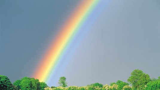 Die Abbildung zeigt einen regnerischen Himmel, über den sich ein Regenbogen spannt. 