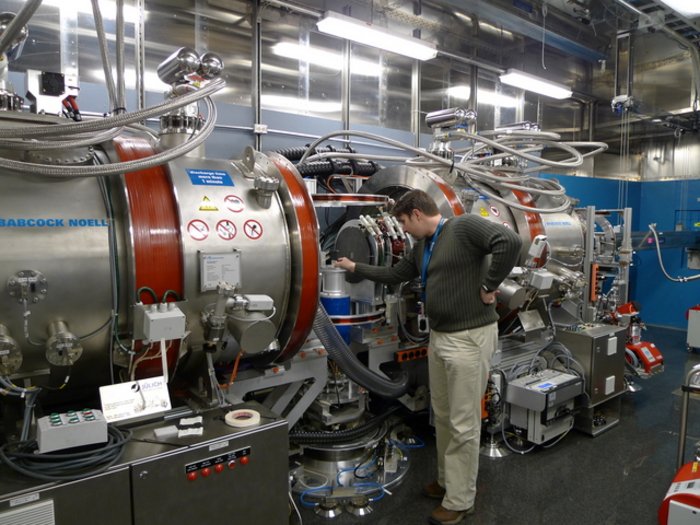Das Neutronenspinecho-Spektrometer Das Neutronenspinecho-Spektrometer sieht weitgehend zylinderförmig aus, mit einem Durchmesser der Röhren von circa 1,5 Metern. Zwei Paare von Spulen zur Erzeugung eines longitudinalen Magnetfelds und ein Spulenpaar für ein transversales Magnetfeld sind erkennbar. Daneben befinden sich eine Reihe von Vakuumpumpen, Steuergeräten und Sensoren an der Maschine.