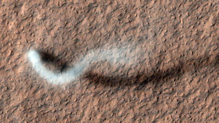 Staubteufel auf dem Mars | Bildquelle: NASA/JPL-Caltech/Univ. of Arizona Ein wolkenartiges Gebilde zieht schlängelnd über die Marsoberfläche