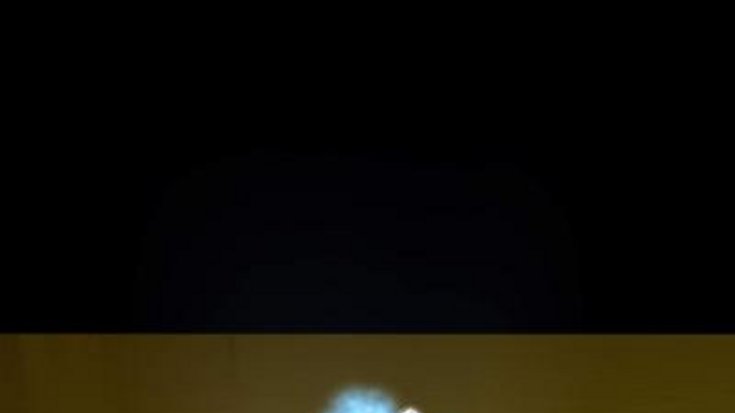 Das Bild zeigt in künstlerischer Darstellung, wie eine Hand aus Licht ein künstliches Atom manipuliert.