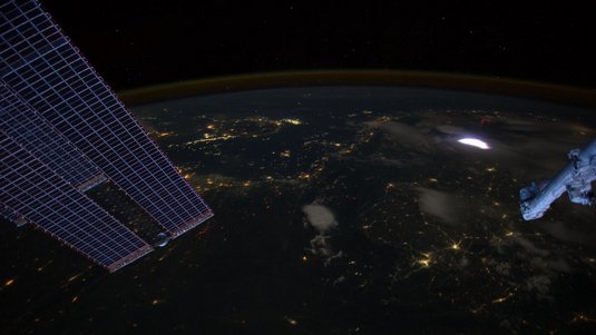 breite Leuchterscheinung in der Erdatmosphäre bei Nacht, fotografiert vom All aus