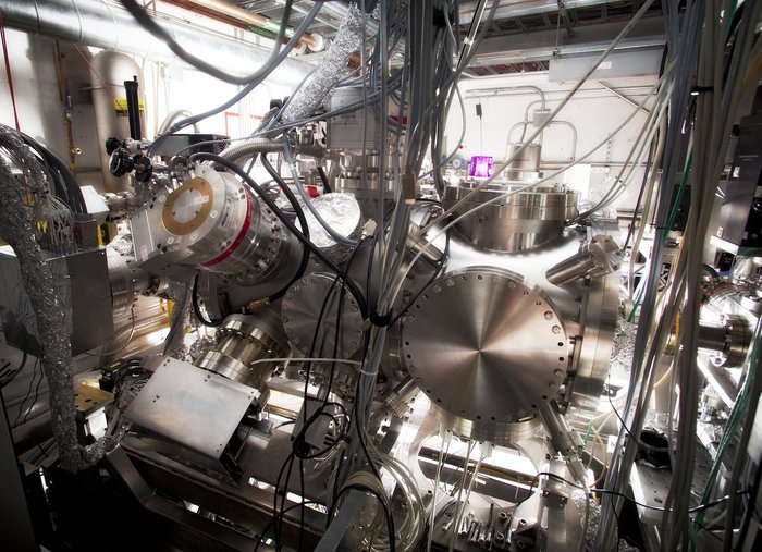 Experimentierkammer am SLAC Zahlreiche Geräte aus Metall, verbunden mit Röhren und Kabeln in einem niedrigen Raum.