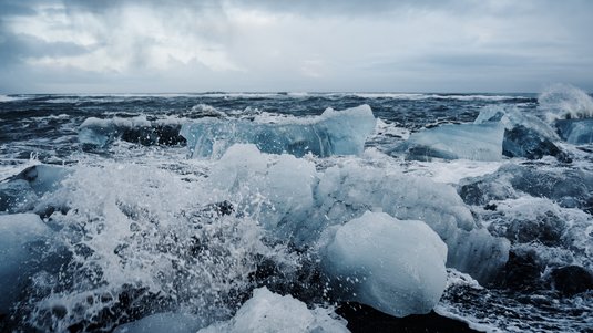 Meereswellen treffen auf Eis am Ufer