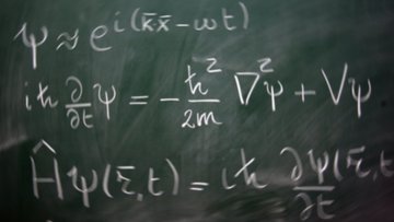 Das Foto zeigt eine Tafel, auf der verschiedene Gleichungen der Quantenmechanik zu sehen sind.
