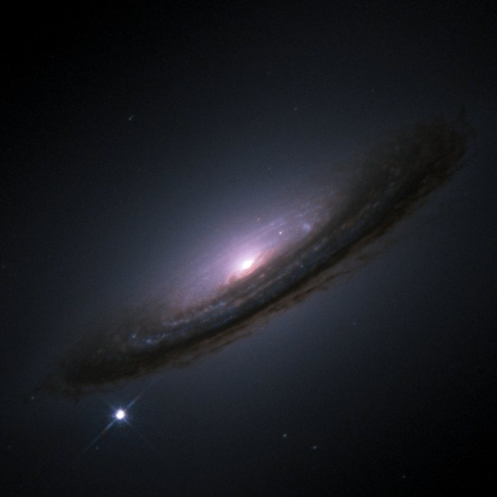 Supernova 1994D Leuchtender weißer Punkt, der von einem dunklen Ring umgeben ist.