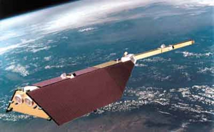 Der Forschungssatellit CHAMP Foto. Im Weltall schwebender Satellit. Darunter Erdoberfläche mit Wolken und Gebirgen. Satellit mit langem Stiel, der ein Drittel der Gesamtlänge ausmacht.