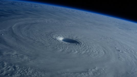 Aufnahme eines Hurrikans vom Weltall aus: Ein großer Strudel sammelt viele Wolken um sich herum.