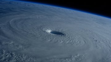 Aufnahme eines Hurrikans vom Weltall aus: Ein großer Strudel sammelt viele Wolken um sich herum.