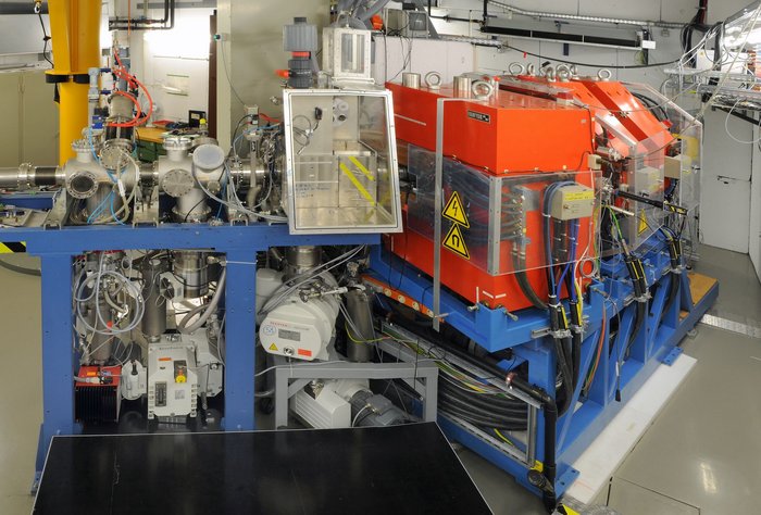 Detektoraufbau TASCA Aufbau des etwa schrankgroßen Detektors, eine silberne Röhre endet in einem orangefarbenen Kasten.