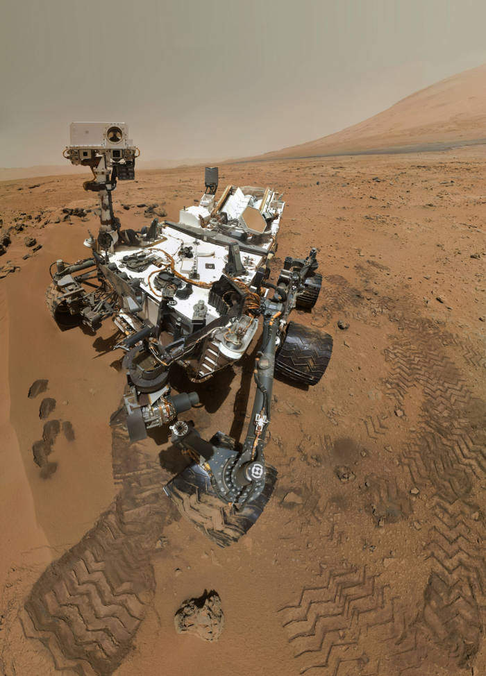 Selbstporträt des Rovers Curiosity Sechsrädriges Fahrzeug mit zahlreichen technischen Aufbauten in Wüstenlandschaft
