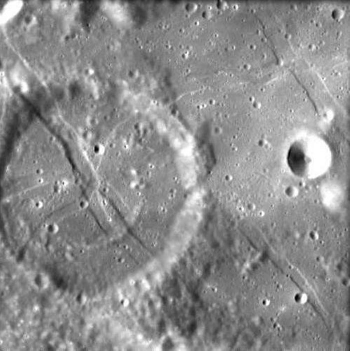 Abdruck eines Balles auf dem Mond? Schwarz-Weiß-Photo einer Mondlandschaft mit einigen kreisförmigen Kratern.