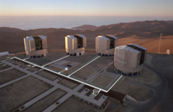 Vier große Teleskope werden durch Lichttunnel mit einigen kleineren Hilfsteleskopen verbunden. Sie stehen auf einem hohen Berg.