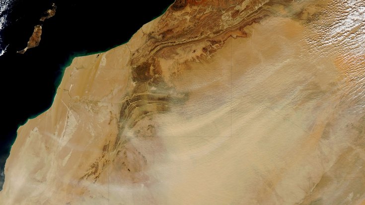 Aufnahme von oben, die die Wüstenlandschaft der Westsahara zeigt.