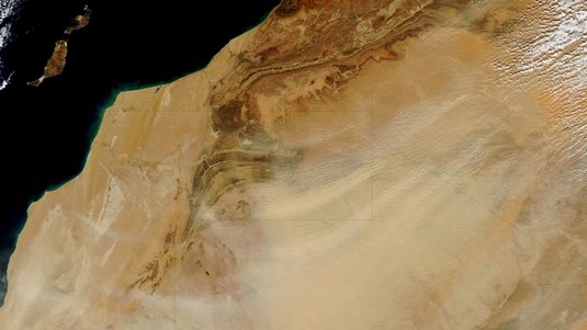 Aufnahme von oben, die die Wüstenlandschaft der Westsahara zeigt.