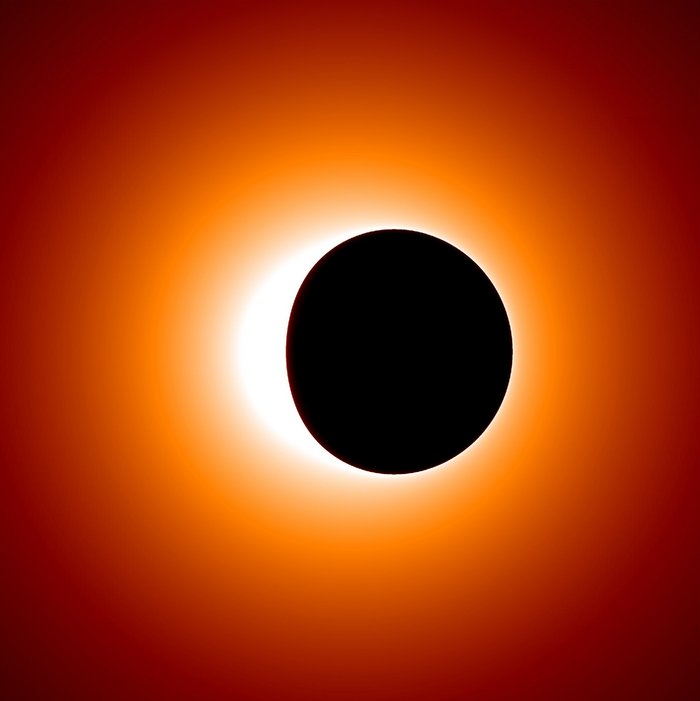 Vor einem roten Hintergrund befindet sich ein eine schwarze Fläche, die auf der rechten Seite zwar kreisrund, auf der linken Seite aber oval abgeflacht ist. Dabei handelt es sich um die Simulation des Schattens, den der Ereignishorizont eines Schwarzen Lochs auf seine Umgebung wirft, die hauptsächlich aus heißem Gas und Staub besteht.