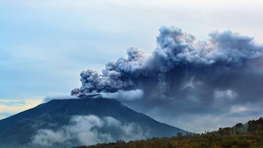 Vulkan und darüber eine große dunkle Wolke