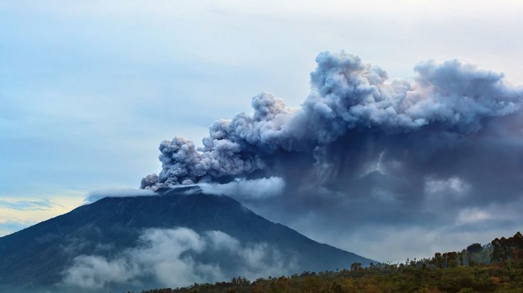 Vulkan und darüber eine große dunkle Wolke